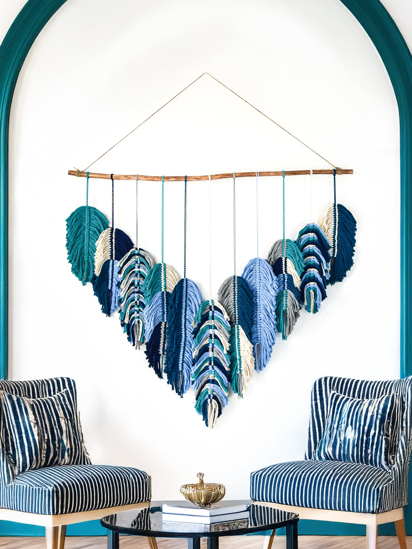 Colorful wall hanging with heart-shaped leaves on a white wall.