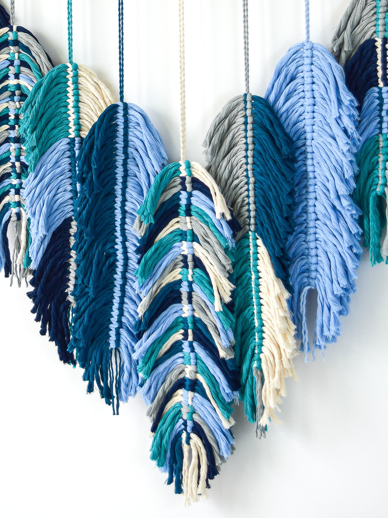 Colorful feather-like decorations hanging against a white background