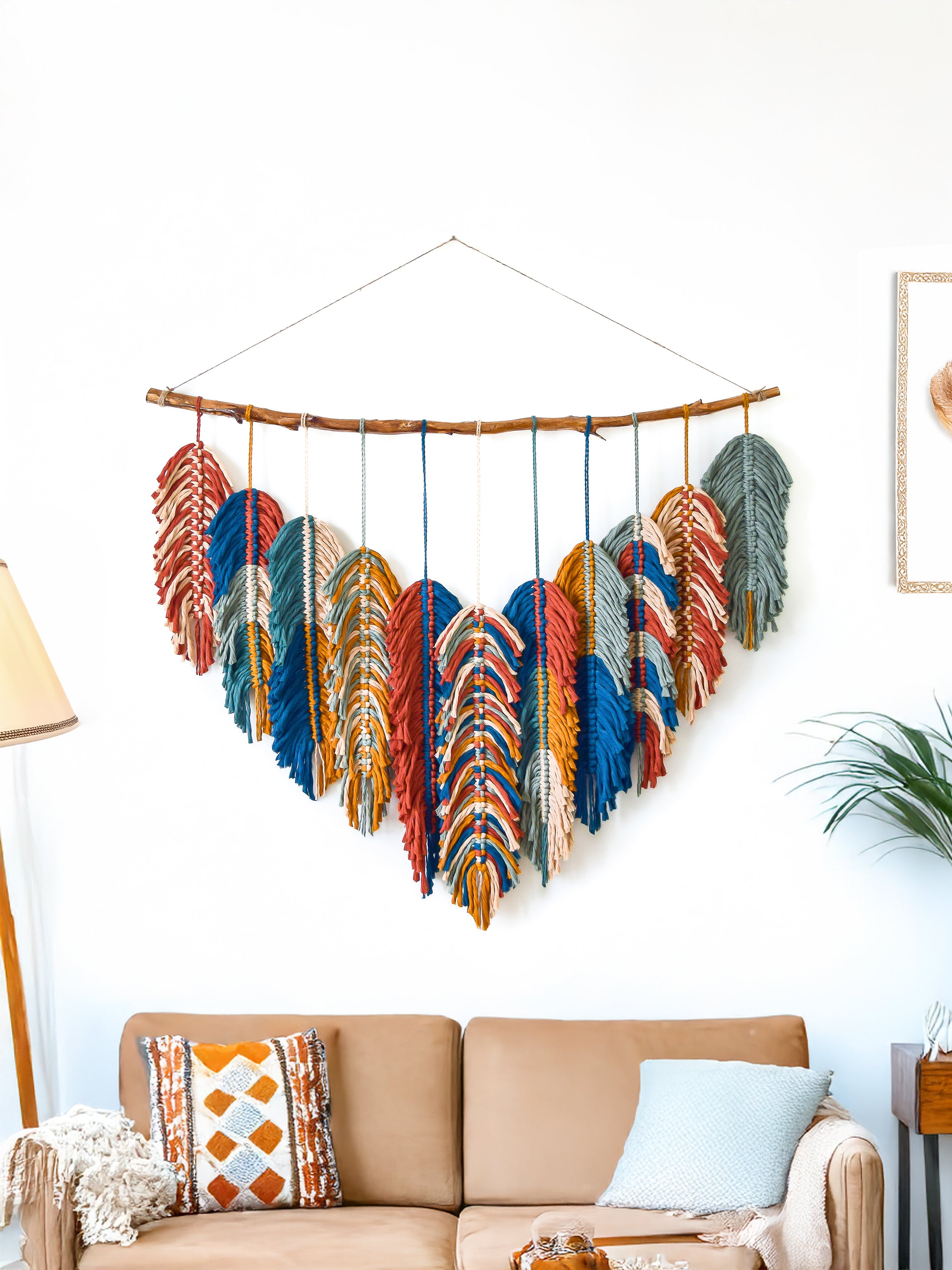 Decorative wall hanging with blue and green feathers in a living room setting.