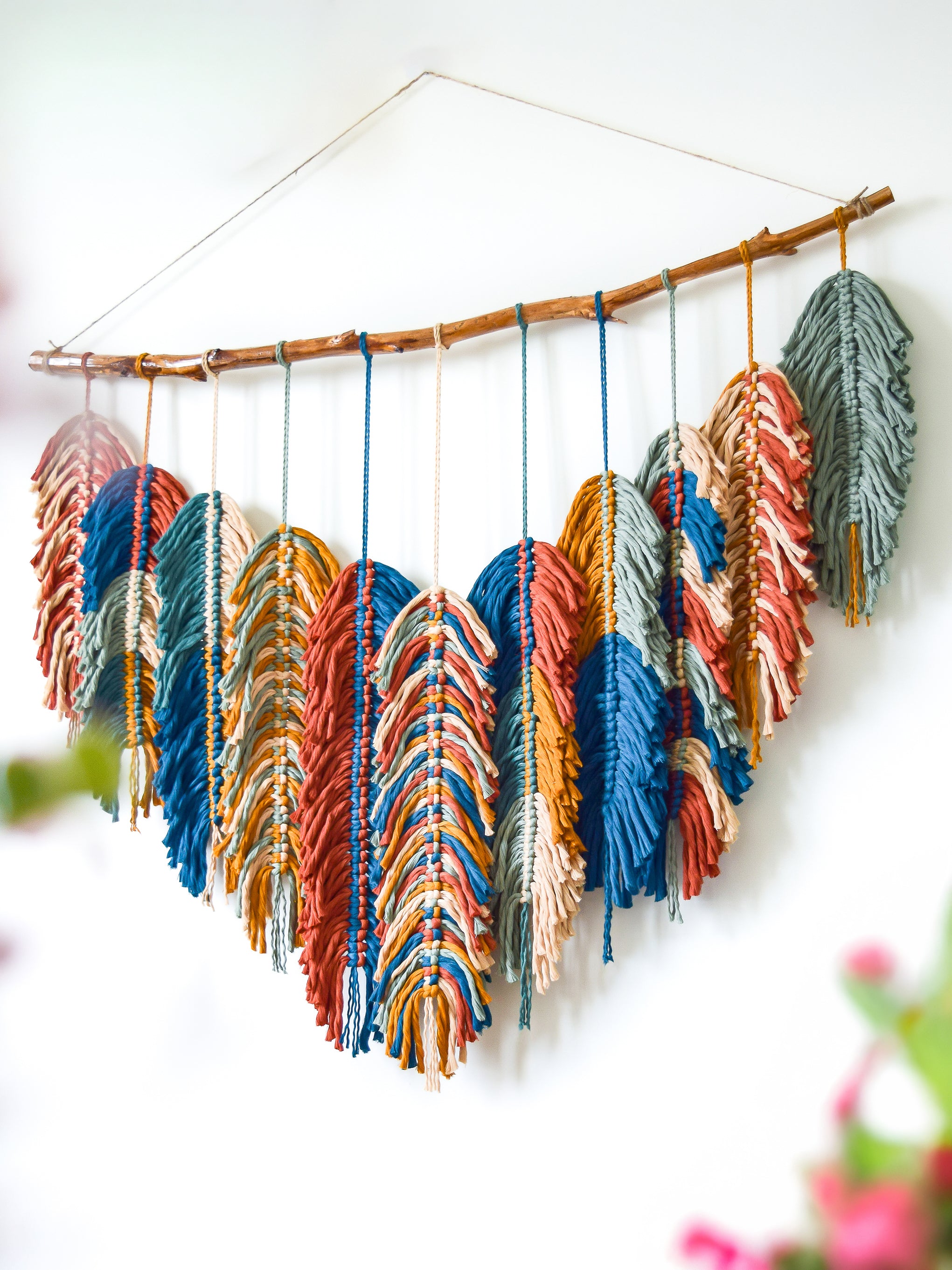 Colorful yarn wall hanging on a white wall
