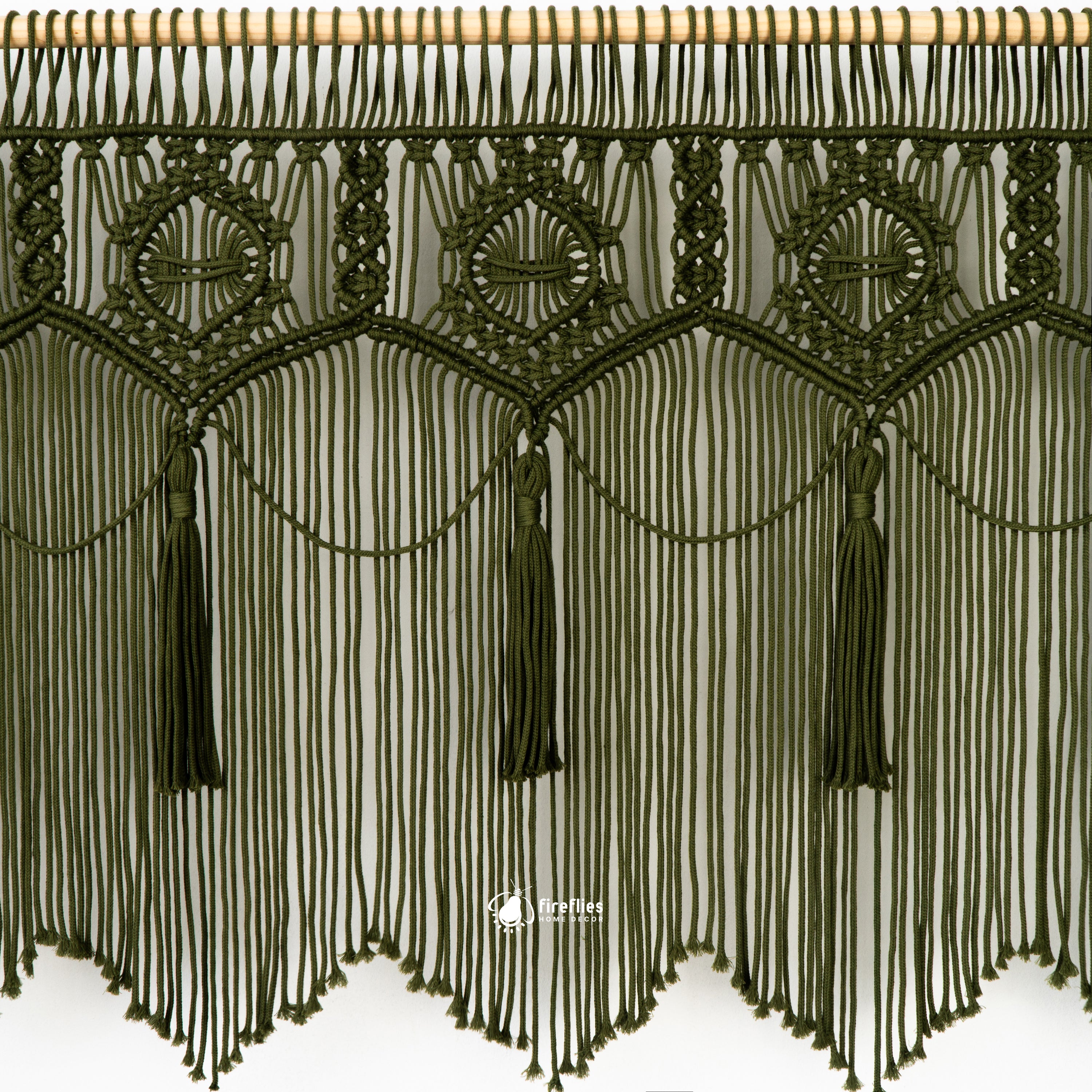 Decorative green macrame fabric with tassels on a white background