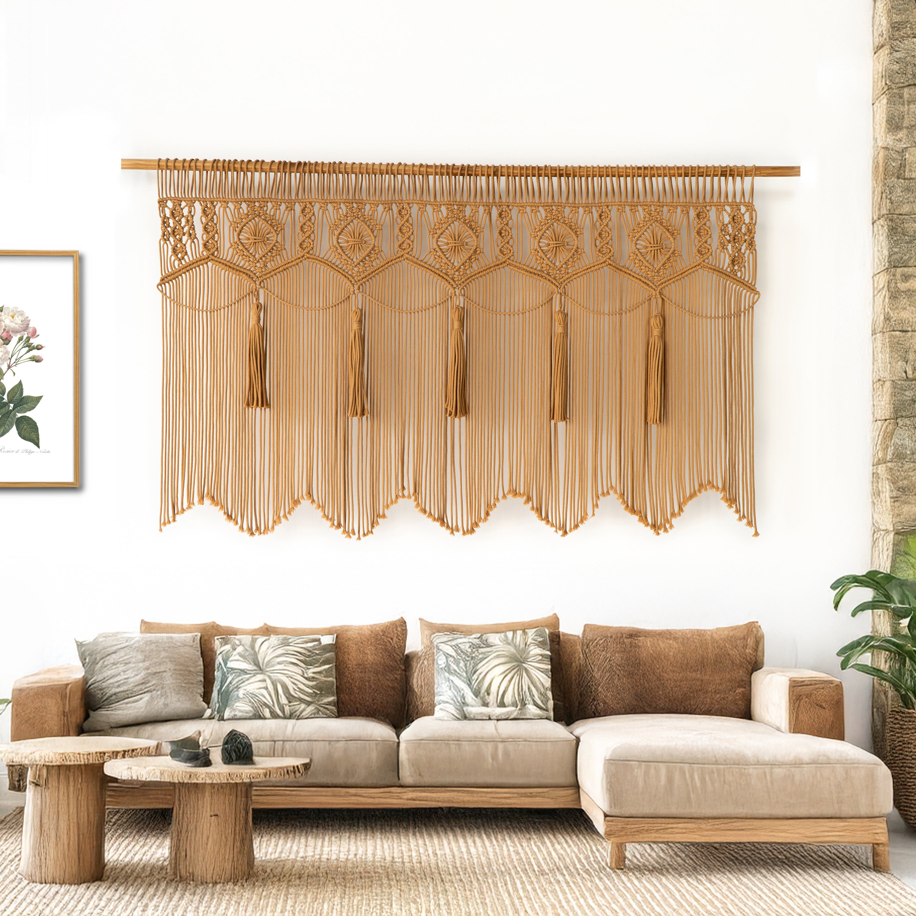 Decorative wall hanging above a beige sofa with decorative pillows in a living room setting.