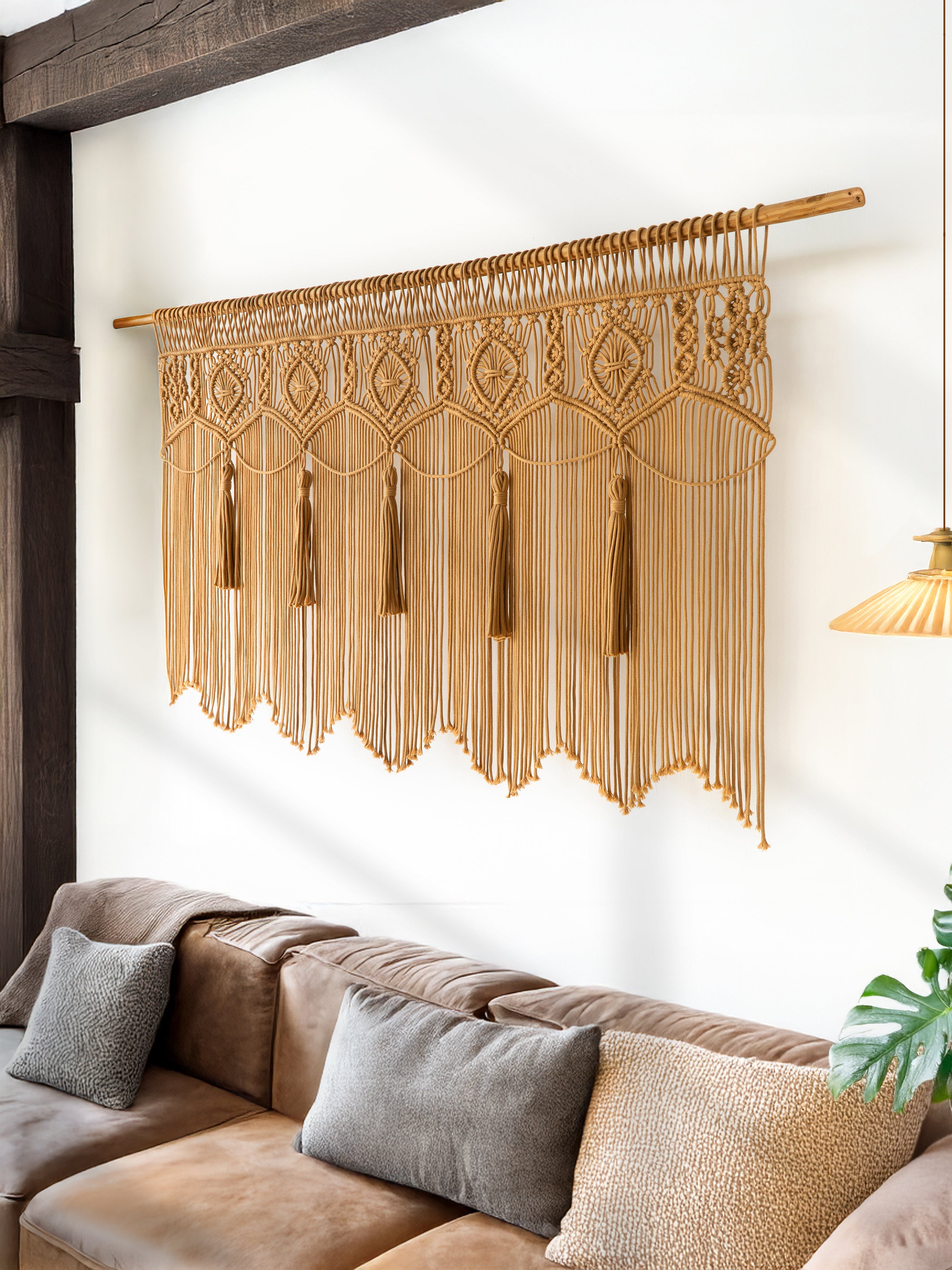 Decorative macrame wall hanging above a sofa in a living room.