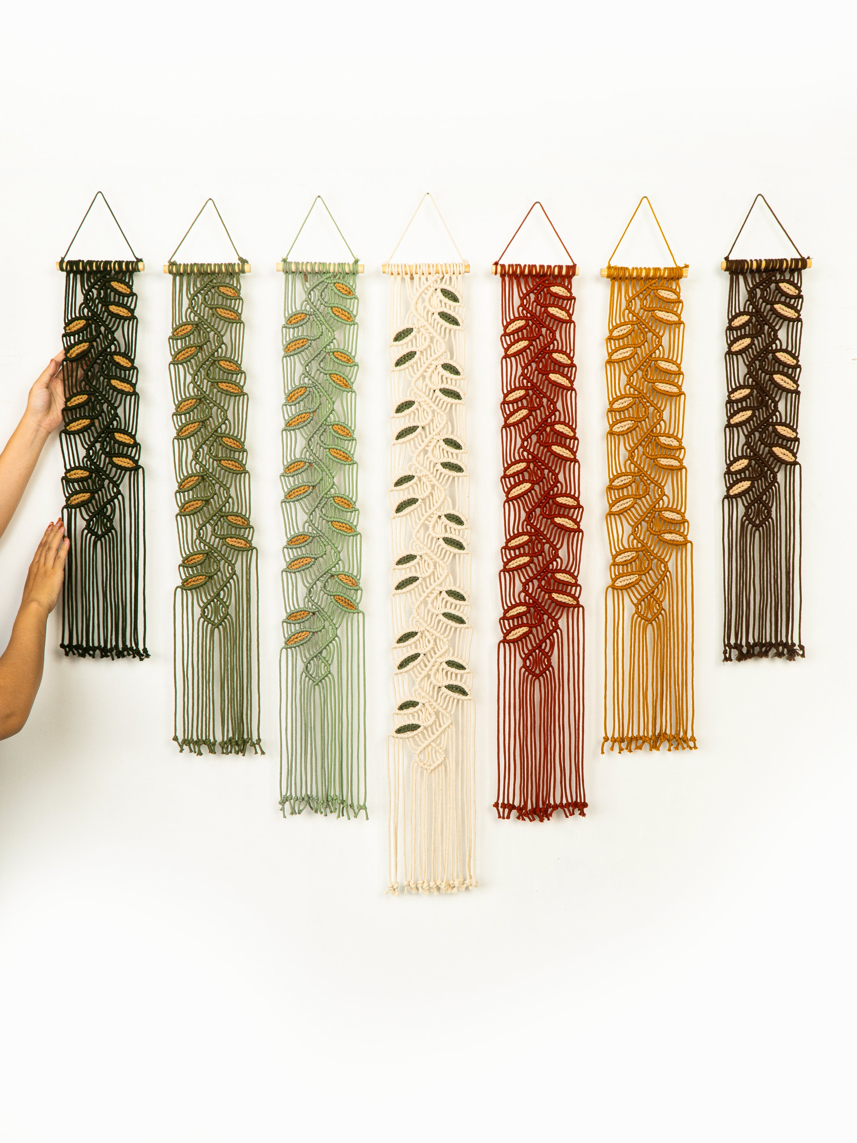 Set of six vertical string art pieces in various colors on a white background