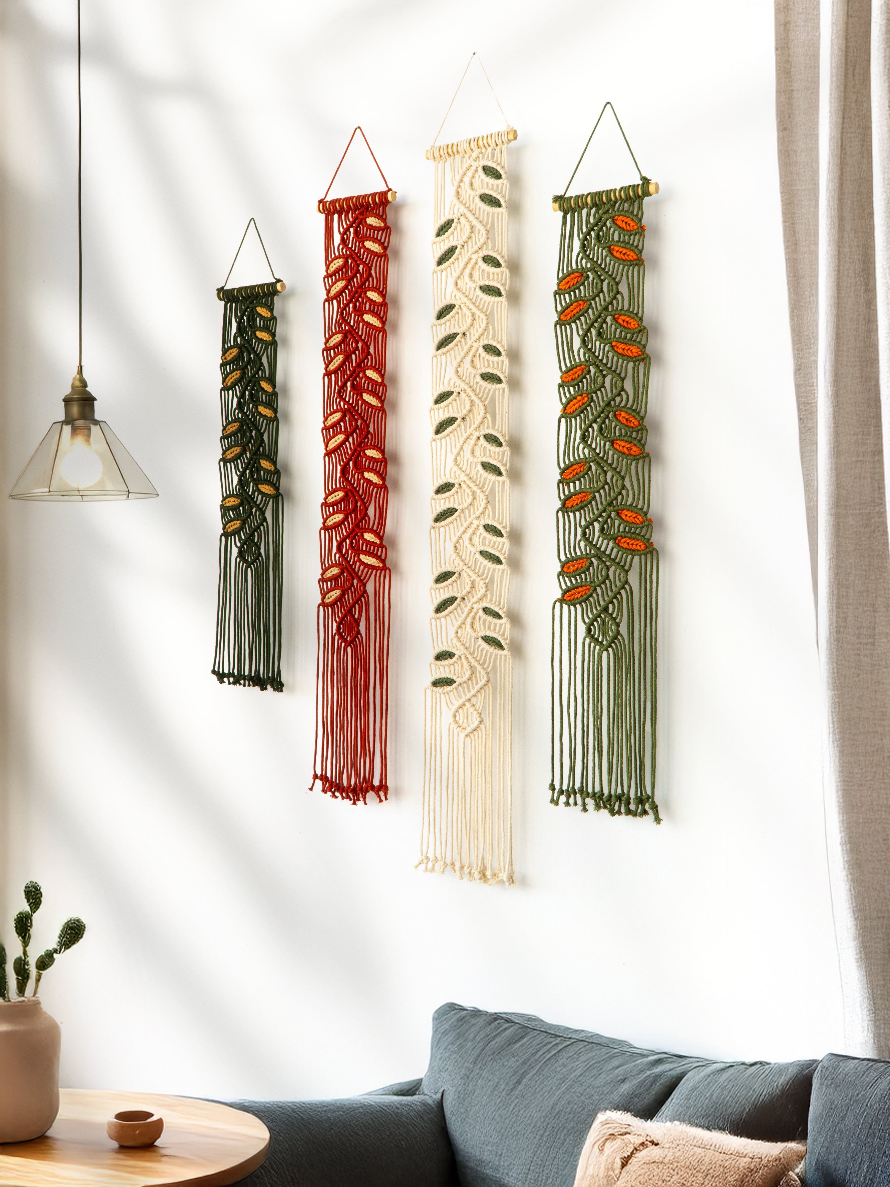 Four decorative wall hangings in various patterns and colors on a white wall.
