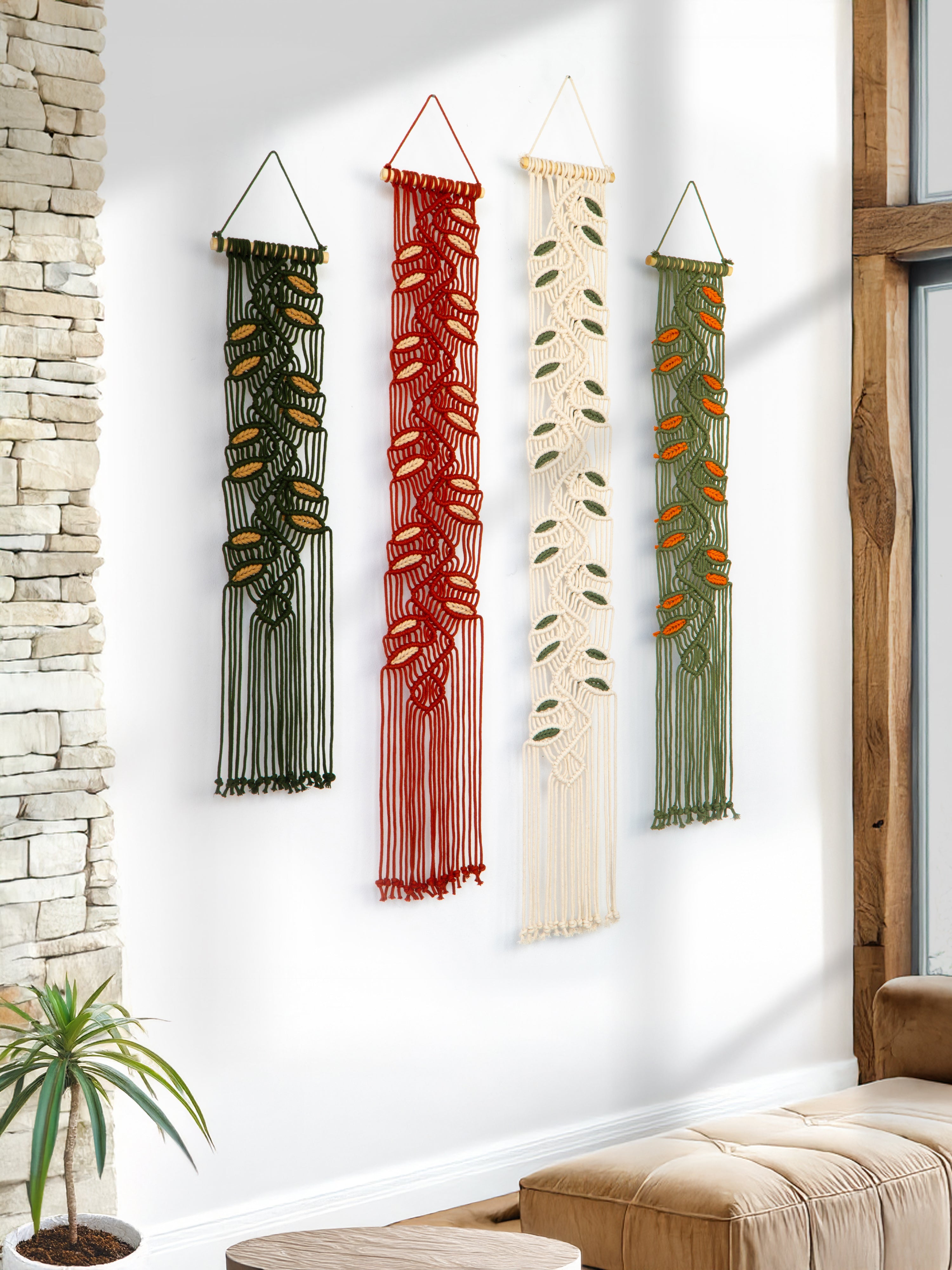 Four vertical wall hangings in different colors on a white wall.