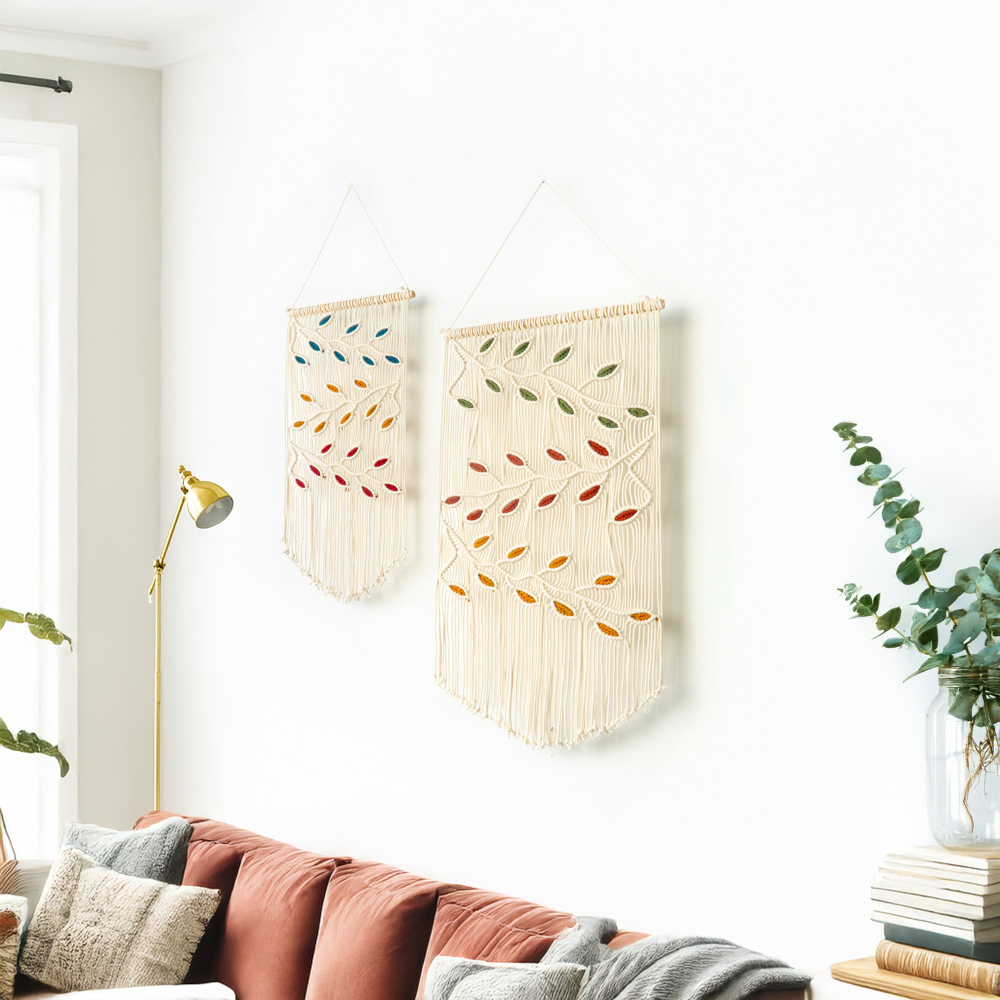 Two wall hangings with colorful patterns on a white wall above a sofa.