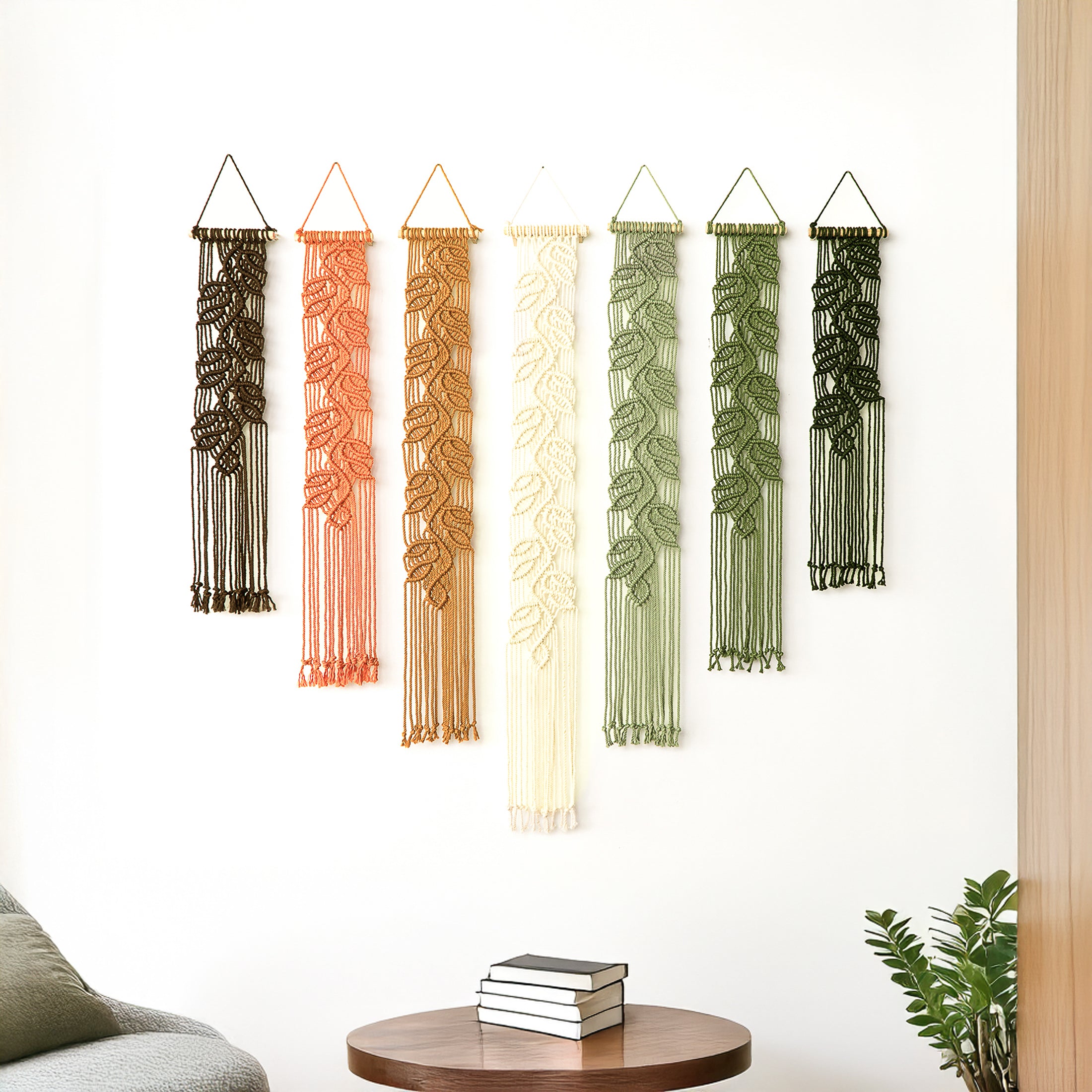 Bohemian textile wall art set of seven pieces with a detailed sculptural leaf design, enhancing a neutral interior space.