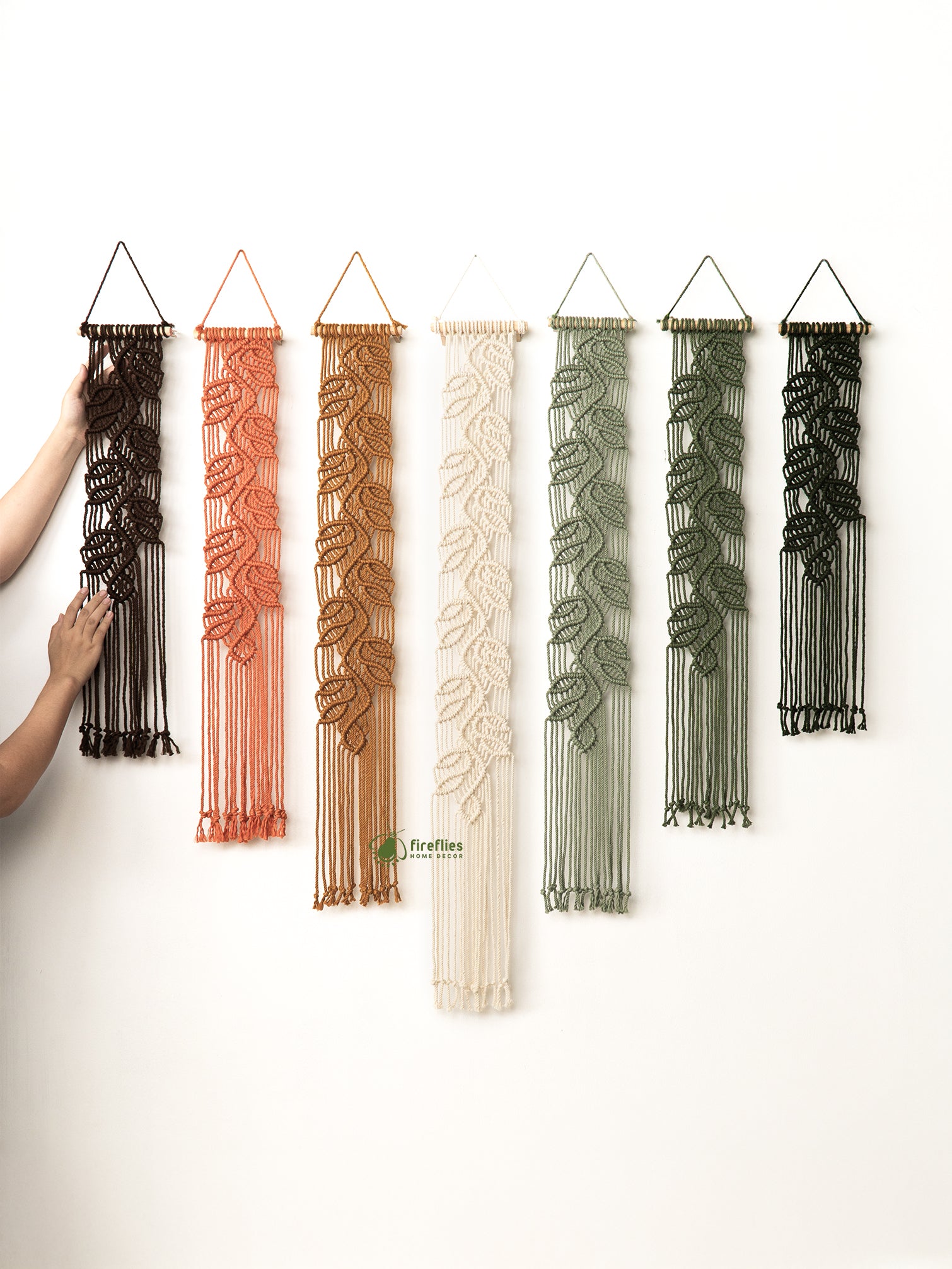 Set of macrame wall hangings in various colors on a white background