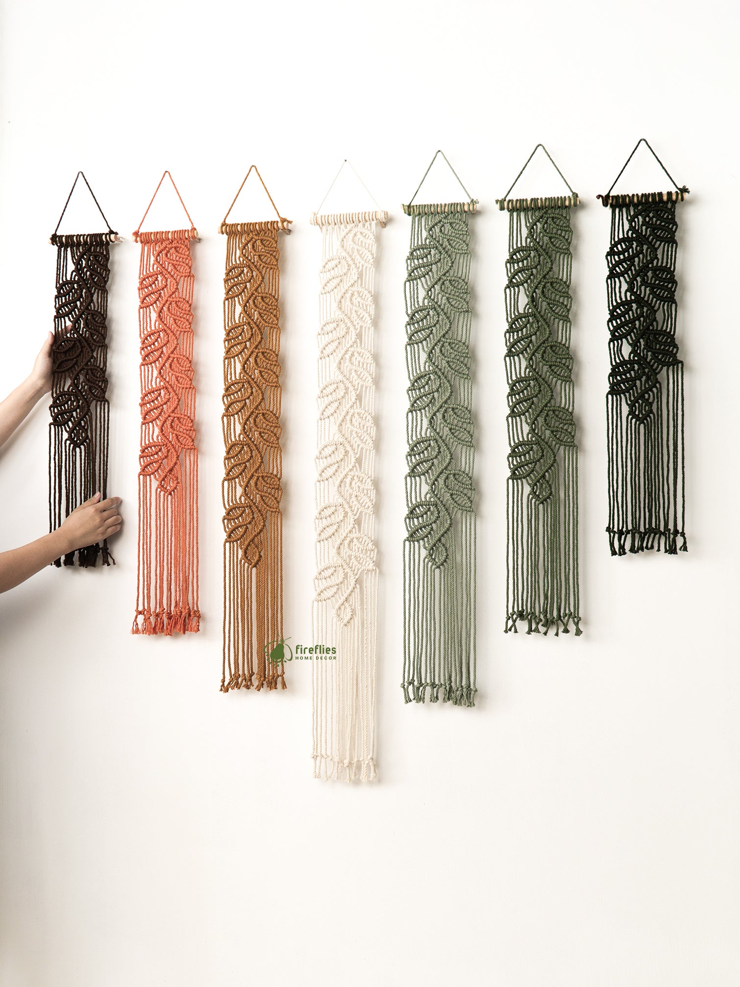 Set of macrame wall hangings in various colors on a white background