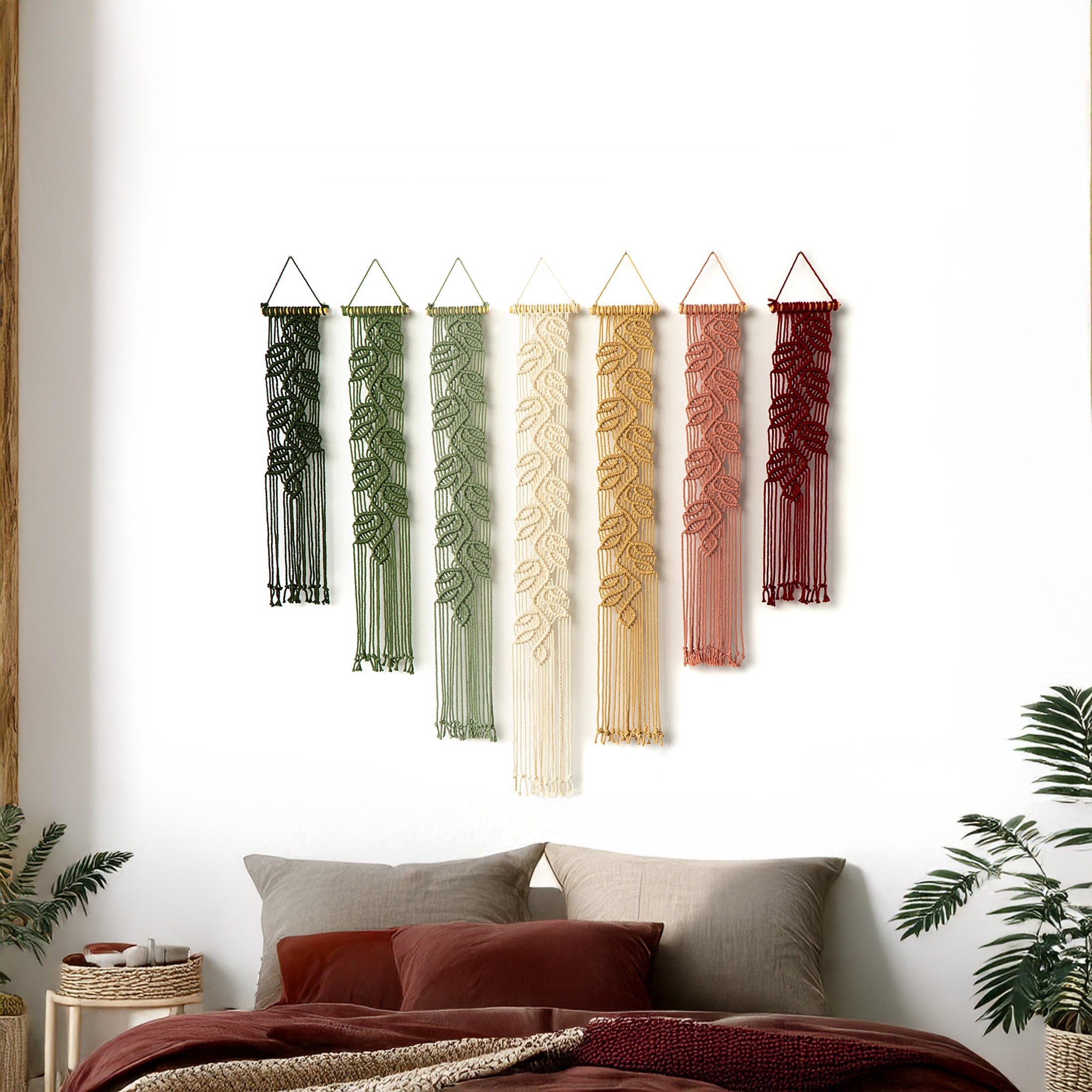 Seven vertical macrame tapestries with a bold leaf pattern, bringing rich, natural colors to a bright interior space.