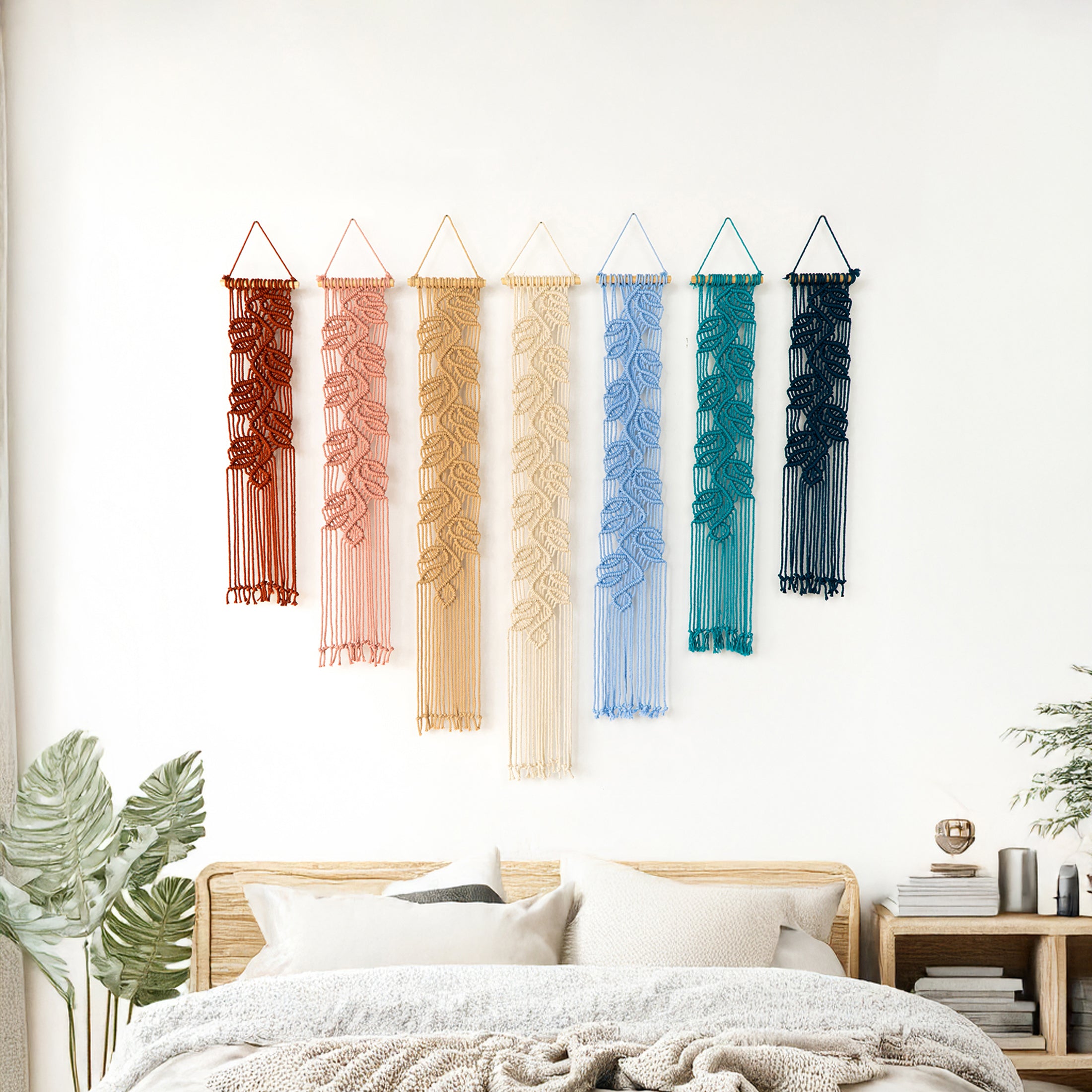Artisan macrame leaf tapestries showing a warm to cool color shift, from rust/orange to deep navy blue.