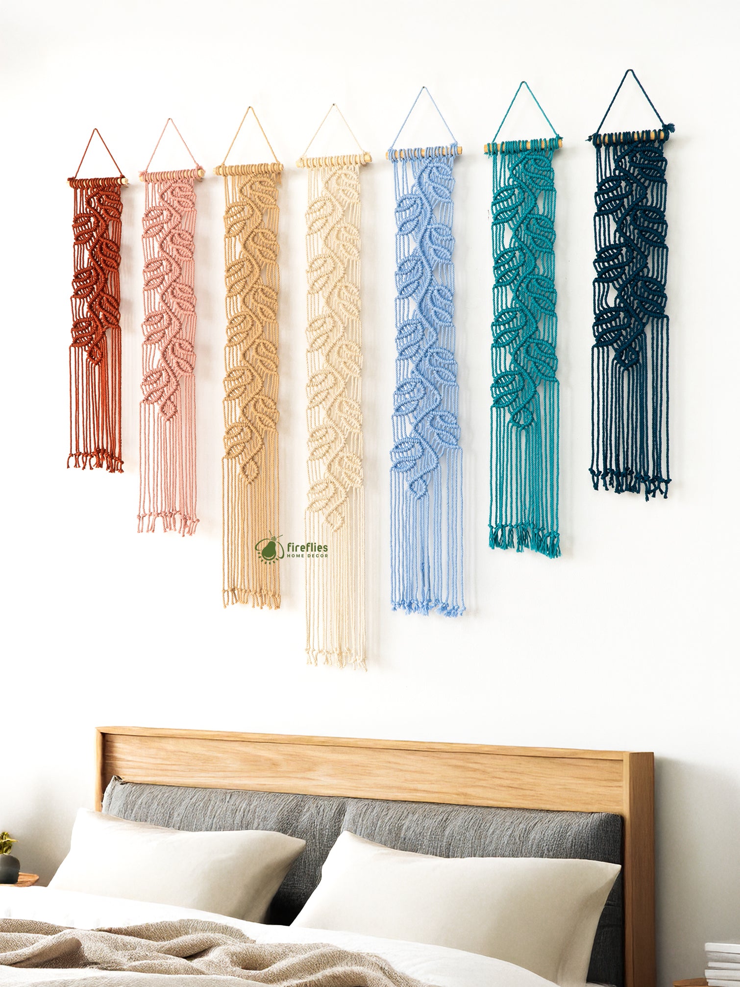 Set of six colorful wall hangings above a gray sofa with brown cushions.