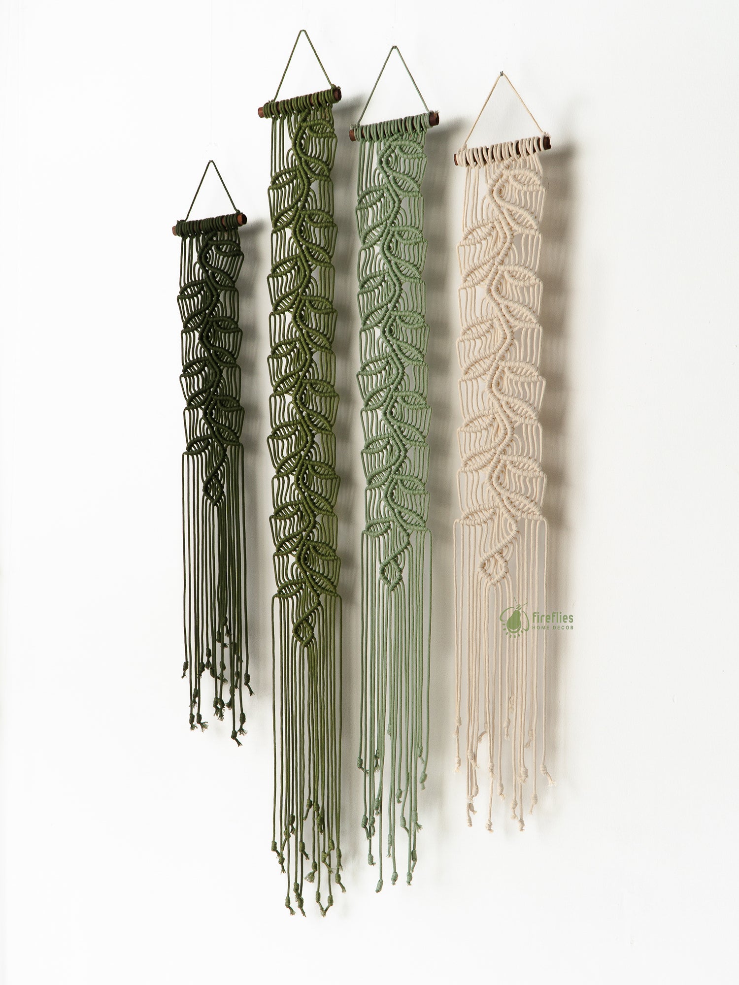 Four macrame wall hangings in different colors on a white background